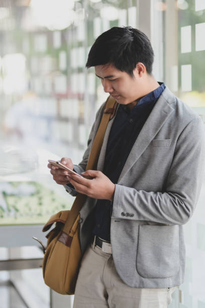 istock Young businessman using smartphone with blurred office room 1194436684
