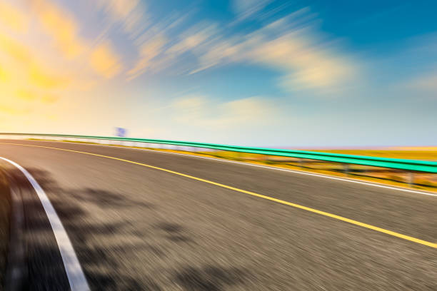 istock Blurred moving asphalt road and colorful sky at sunset 1194437042