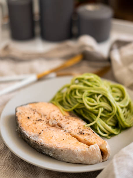 istock green spaghetti and grilled salmon steak. Top view 1194438262