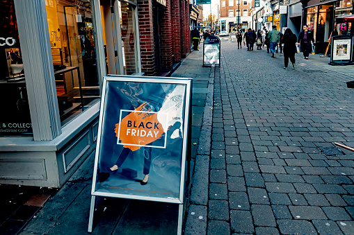 2019 Black Friday sign outside a shop in Nottingham, England, UK. This is on a cobbled street with stores either side and Christmas shoppers in the background.