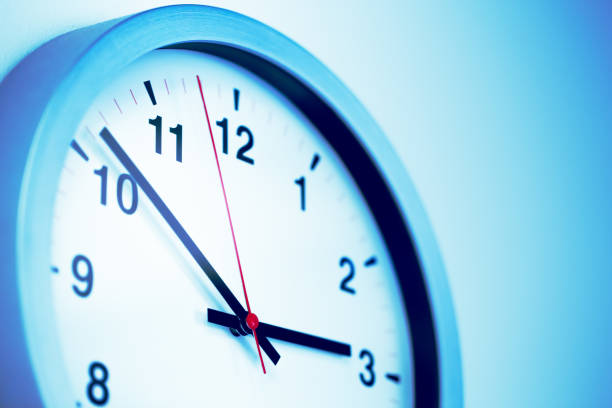 istock Closeup times clock part hanging on the wall for working hours  blue colour tone. 1194439055