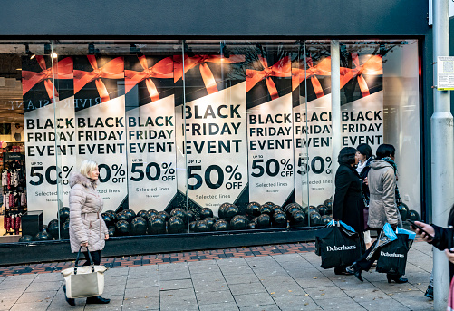 2019 Black Friday signs on a shop in Nottingham, England, UK. There are Christmas shoppers in the foreground.