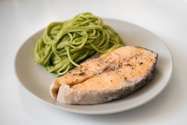 istock green spaghetti and grilled salmon steak. Top view 1194439901