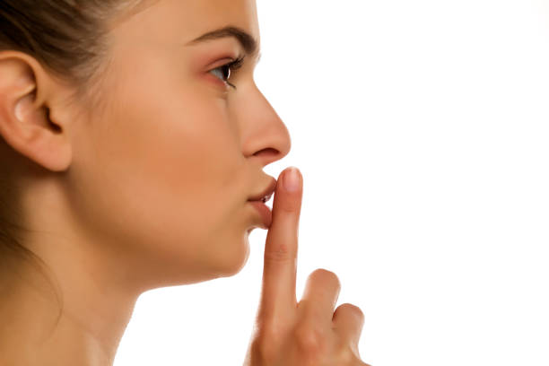 istock Young woman with finger on her lips on white background 1194440393