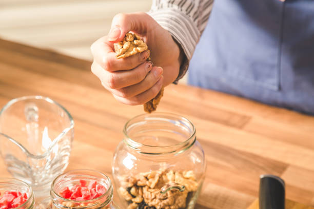istock Close-up of woman using walnuts while preparing food. 1194440540