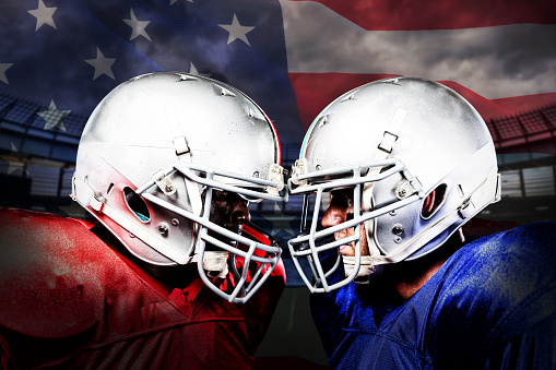 Two American football players head to head against close-up of an american flag