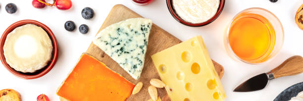istock Cheese platter flatlay panorama on a white background. Blue cheese, red, goat cheese, and others, with wine, fruits and almonds 1194446497