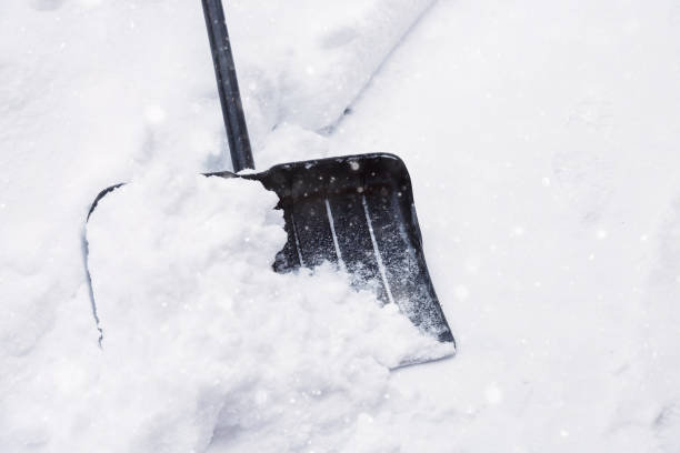 istock Snow cleaning concept. Black shovel and snow during snowstorm. 1194446574