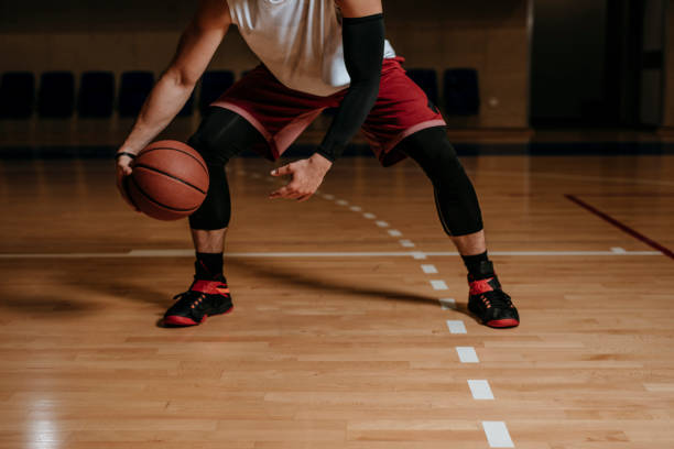 joueur de basket-ball dribblant une bille - dribbler sports photos et images de collection