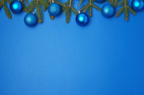 istock green spruce branches, blue shiny Christmas balls on a blue background, festive backdrop 1194448060