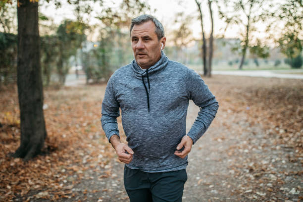 istock Senior man jogs into a public park 1194449373