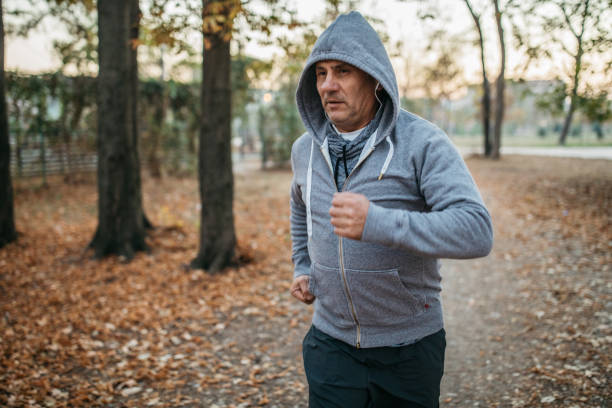 istock Senior man jogs into a public park 1194449408