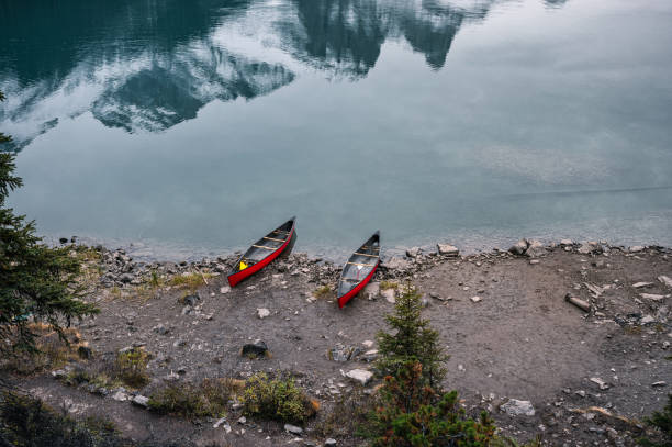 istock Two red canoe parked on coastline in Maligne lake 1194449773