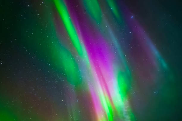 aurora borealis in night northern sky. ionization of air particles in the upper atmosphere. - ionization imagens e fotografias de stock