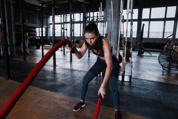 istock Fit woman using battle ropes during strength training at the gym. 1194451781