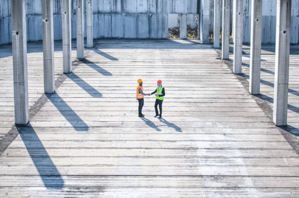 istock High Angle View of Construction Site Coworkers Shaking Hands 1194454923
