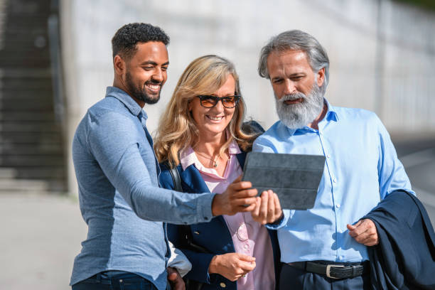 istock Business Friends Pausing to Take Selfie on Digital Tablet 1194455104