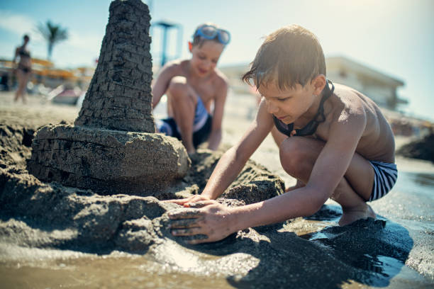 istock Little boys building sandcastle on beach 1194457170