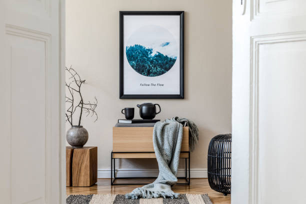 istock Modern scandinavian living room interior with mock up poster frame, design commode, flower in vase, black rattan basket, books , tea pot and elegant accessories. Template Stylish home staging. Japandi 1194459326