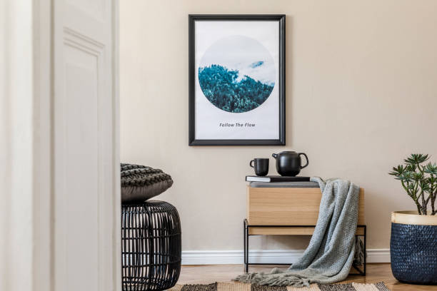 istock Modern scandinavian living room interior with black mock up poster frame, design commode, rattan basket with plants, books, tea pot and elegant accessories. Template. Stylish home staging. Japandi. 1194459345
