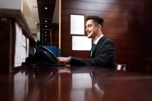 Young receptionist coordinating front-desk activities, hotel service management