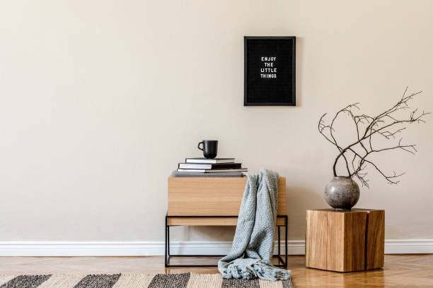 istock Modern scandinavian living room interior with mock up poster frame, design wooden commode, tea pot, wooden cube, flowers and elegant accessories. Beige concept. Stylish home decor. Ready to use. 1194459368