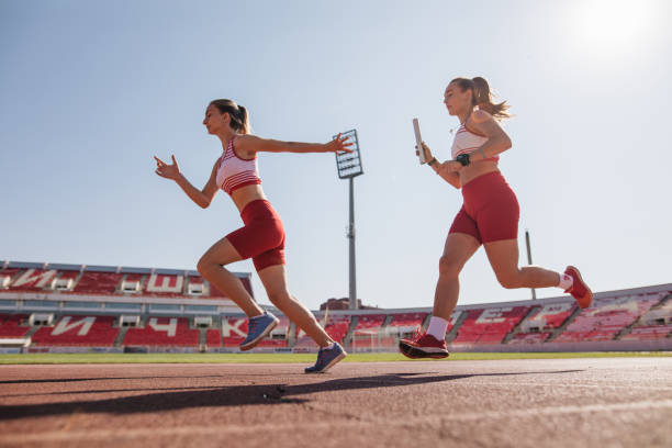 istock Female athletes with a relay baton on a running track 1194459376