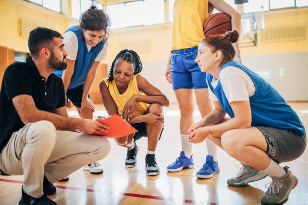istock Female basketball team talking strategy with coach 1194459407