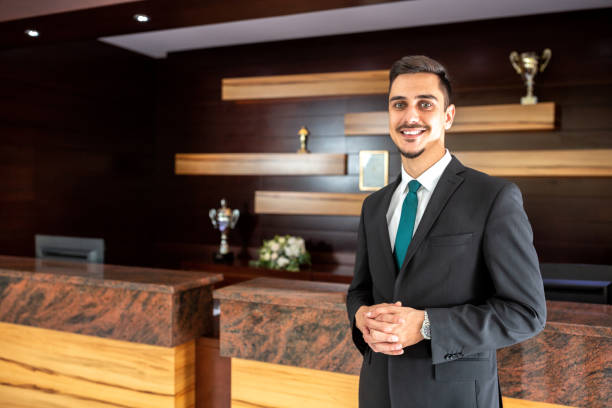istock Smiling hotel worker welcoming guests 1194459421