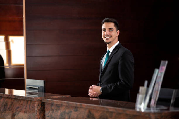 istock Young receptionist standing behind the front desk 1194459579