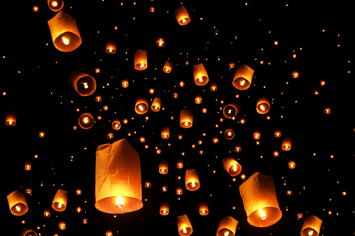 swarms of sky floating lanterns are launched into the air during New year's eve and Yee Peng lantern festival traditional at Chiang Mai , Thailand.
