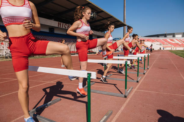 istock Female athletics team hurdling on a stadium 1194460482
