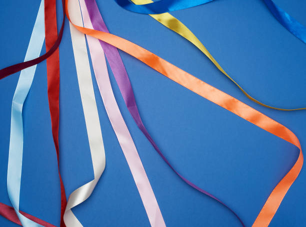 istock many silk multi-colored ribbons on a blue background 1194460574