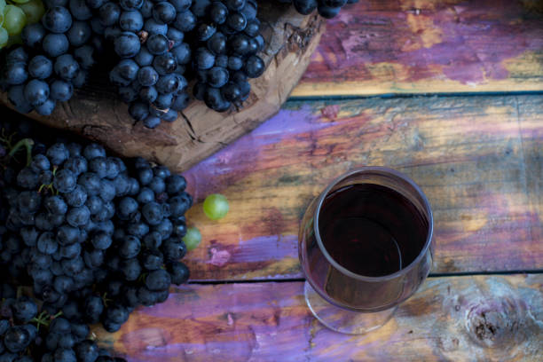 istock Ripe grapes and red wine on a wooden table. 1194460594