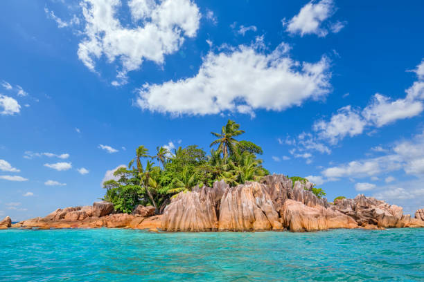 Ile St. Pierre is an uninhabited island of the Seychelles. It is located north of the island of Praslin in the east of Curieuse Island on the edge of the Curieuse Marine National Park. The distance from the island to Pointe Zanguilles on Praslin is 1.5 km. The waters around Île St. Pierre are a firm favourite with swimmers, snorkellers and yachtsmen for whom the island provides the ideal backdrop to a spectacular Seychelles sunset. One of several islands in the bay of Côte d'Or on Praslin, this tiny islet with its granite profile interspersed with some Coconut palms has come, over the years, to represent the quintessential Seychelles island, appearing in numerous advertisement campaigns, posters and evocative photographs. Seychelles, officially the Republic of Seychelles, is an archipelago country in the Indian Ocean. The Granitic Seychelles are the islands in the Seychelles which lie in central position on the Seychelles Bank and are composed of granite rock. They make up the majority of the Inner Islands, which in addition include the coral islands along of the rim of the Seychelles Bank, namely Bird Island and Denis Island.