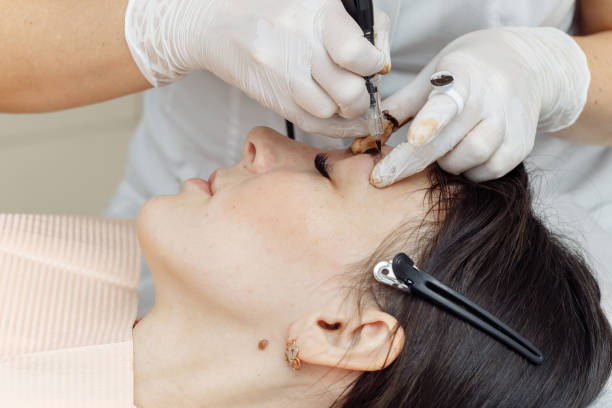 istock Permanent makeup, tattooing of eyebrows. Cosmetologist applying make up 1194464378