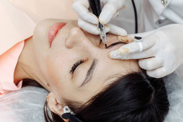 istock Permanent makeup, tattooing of eyebrows. Cosmetologist applying make up 1194464387
