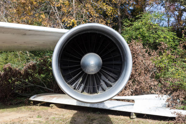 Large jet fuel engine hanging off wing of massive plane on a sunny day