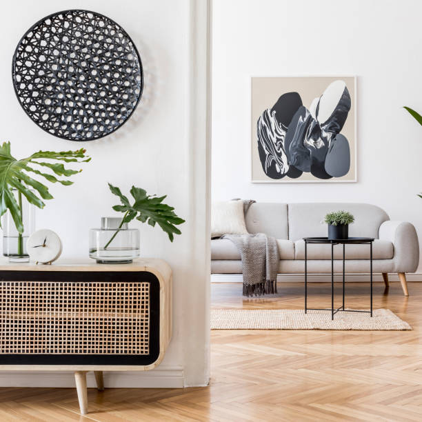 istock Scandinavian and design home interior of open space with wooden commode, gray sofa, design black rattan decoration, tropical leafs and elegant personal accessories. Stylish art home decor. Template. 1194464657