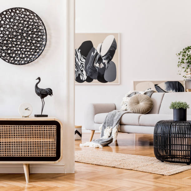 conception intérieure scandinave moderne de l'espace ouvert avec commode en bois élégante, sofa gris, table de rotin, plante, feuille tropicale et accessoires personnels élégants. modèle élégant de décor à la maison. mise en scène à domicile - vehicle interior photos photos et images de collection