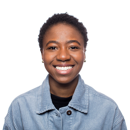 Shot of happy young woman with short hair against white background. Close-up portrait of african american female looking at camera and smiling.