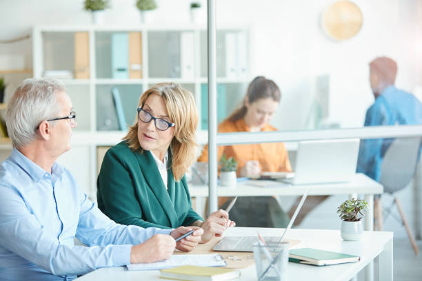 istock Mature colleagues discussing work together 1194466793