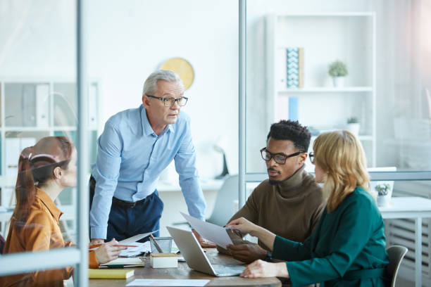 istock Male mature leader with his team 1194469229