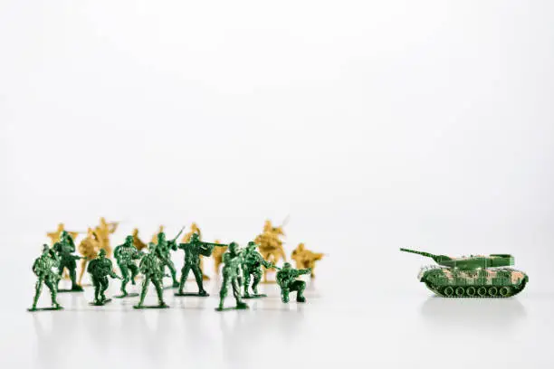 Photo of Battle, small army with toy soldiers are standing against the tank