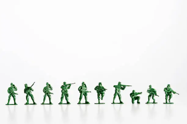 Photo of Plastic toy soldiers are standing in a row on a white background