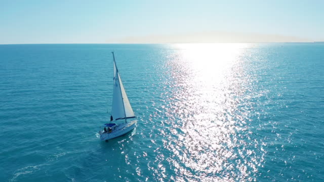 Aerial view. Yacht sailing on opened sea. Sailing boat. Yachting video footage. Yacht from above. Sailboat view from drone