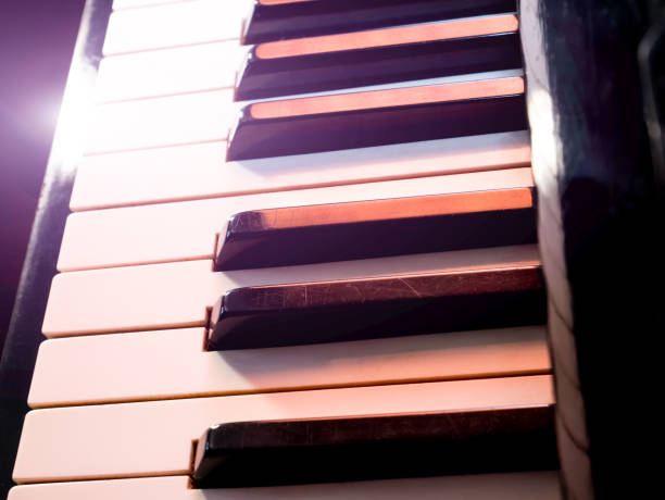 istock Old retro piano keys. close up view. Black and white keys, octave. Lighting effect 1194472525