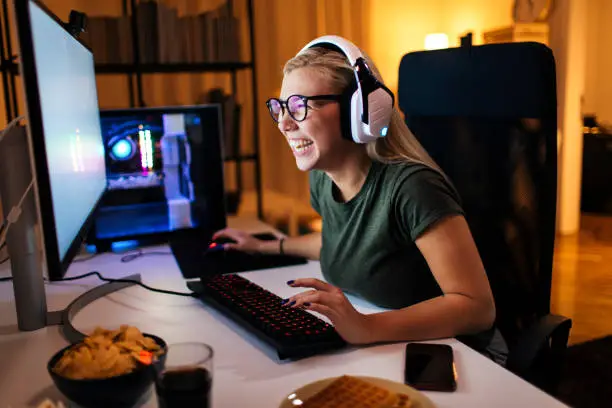 Handsome young blonde playing a video game on her computer