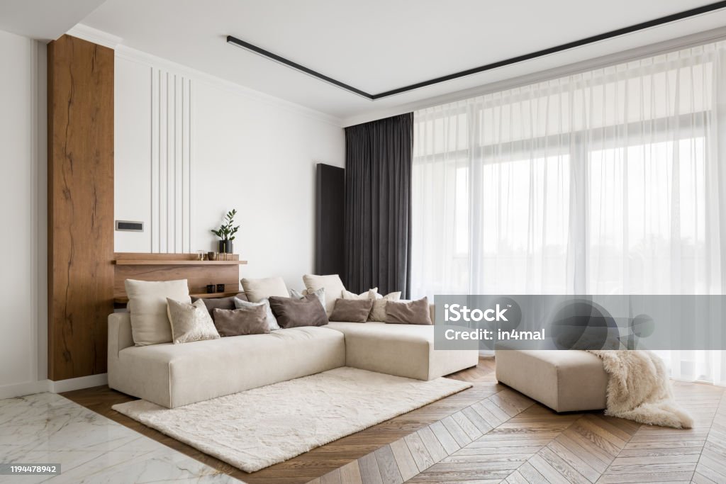 Elegant and comfortable living room Elegant and comfortable designed living room with big corner sofa, wooden floor and big windows Living Room Stock Photo