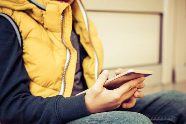 istock Close-up of kid using mobile phone outdoors. 1194483291